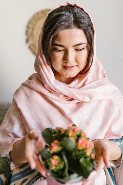 Woman In Pink Veil Holding A Bunch Of Flowers