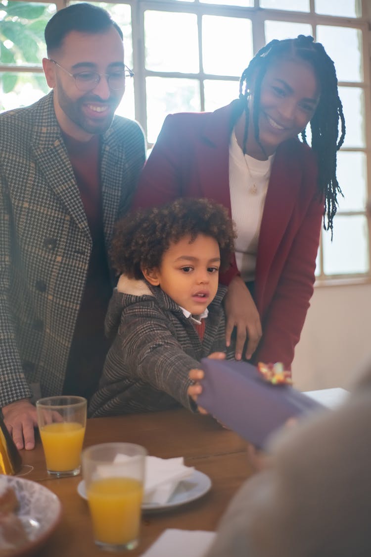 A Boy Handing Out A Gift To A Person