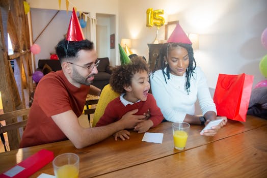 A joyful family celebrating a birthday together using a video call indoors.