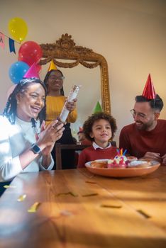 Joyful family birthday party indoors with balloons and cake, celebrating together.