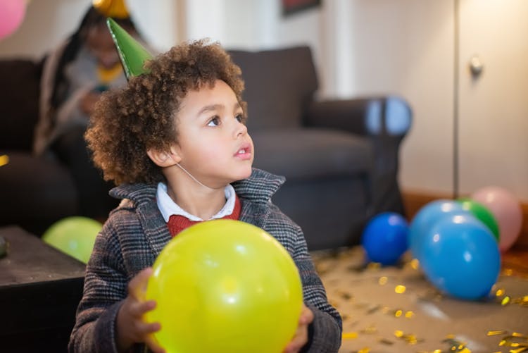 A Boy Holding A Yellow Balloon