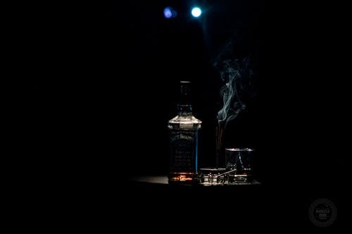 Крупным планом фото бутылки ликера на черном фоне