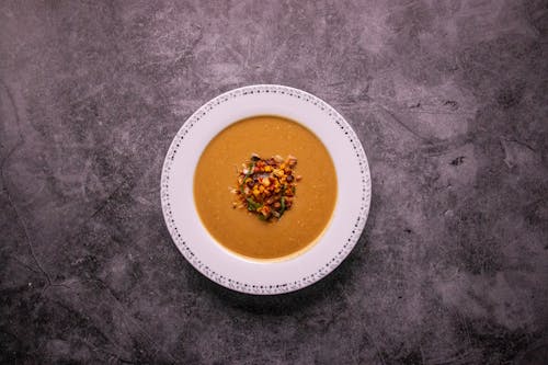 A Flatlay Shot of a Bowl of Soup on a Rustic Background