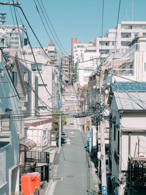 Free High angle of empty narrow asphalt road between typical residential buildings against cloudless blue sky on sunny day in Tokyo Stock Photo