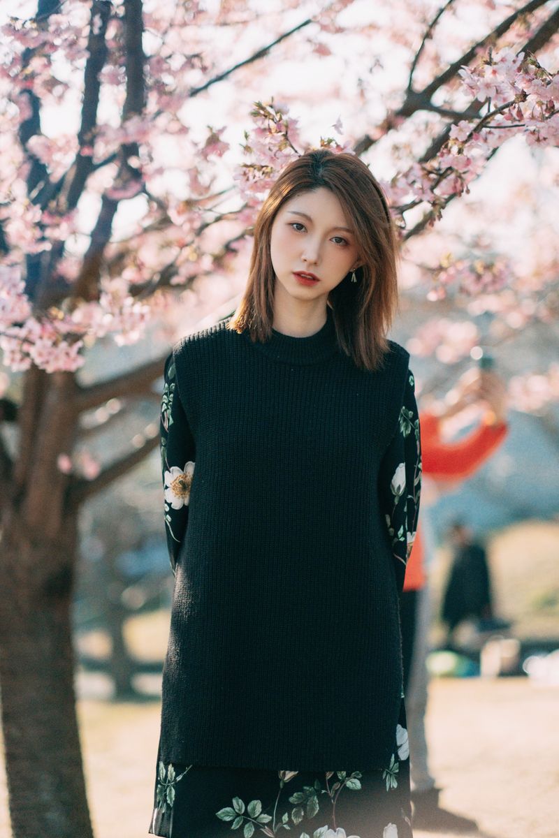 woman in floral midi skirt and fitted black knit top