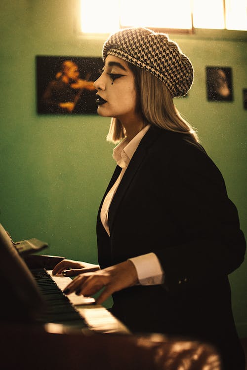 A Woman with a Clown Makeup in a Black Blazer Playing Piano