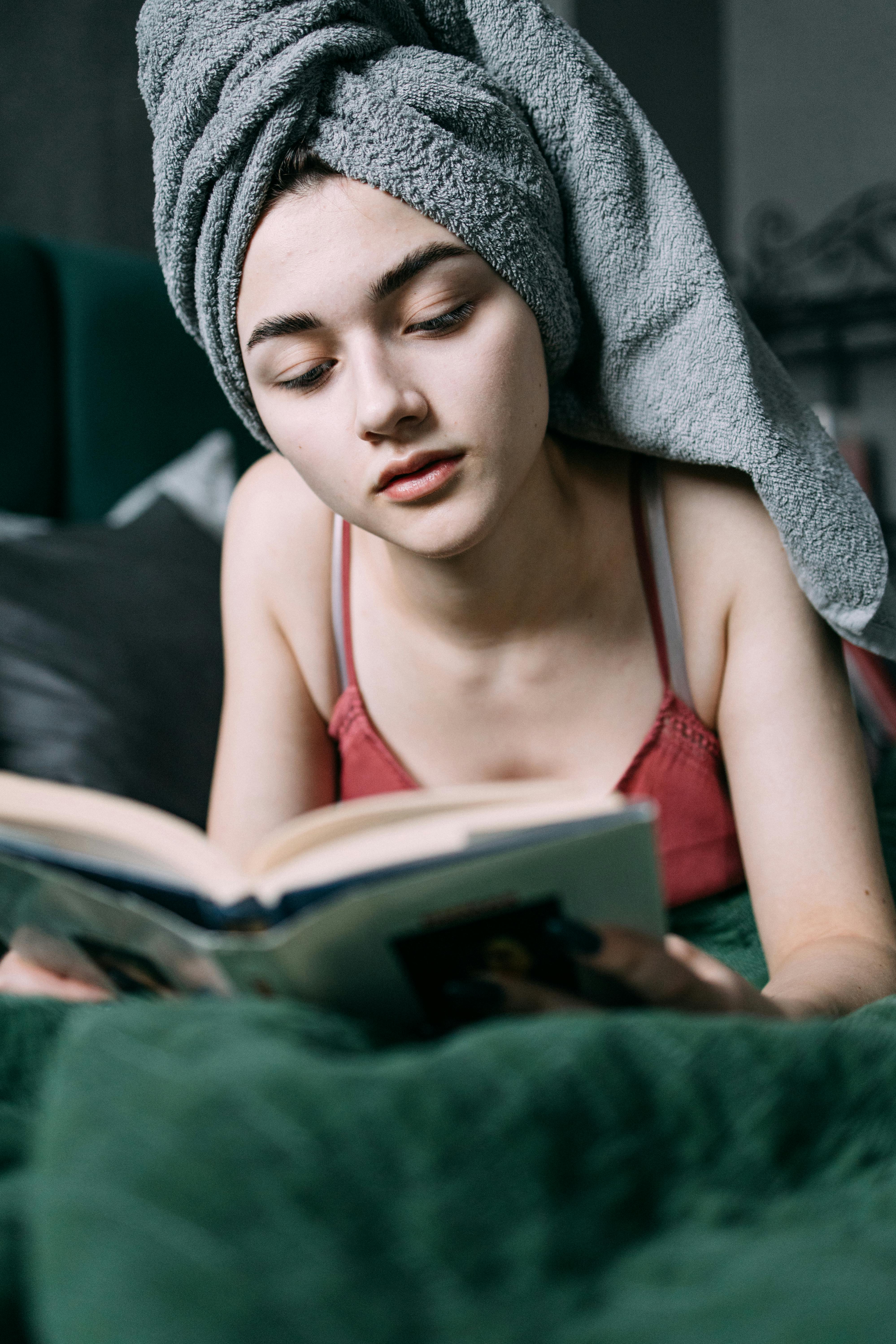 Woman Lying Down on the Bed While Reading a Book · Free Stock Photo