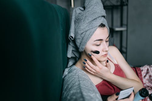 Woman in Head Towel Applying Face Mask 