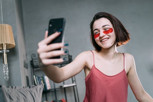 Free Woman with Red Eye Patches Taking Selfie Stock Photo
