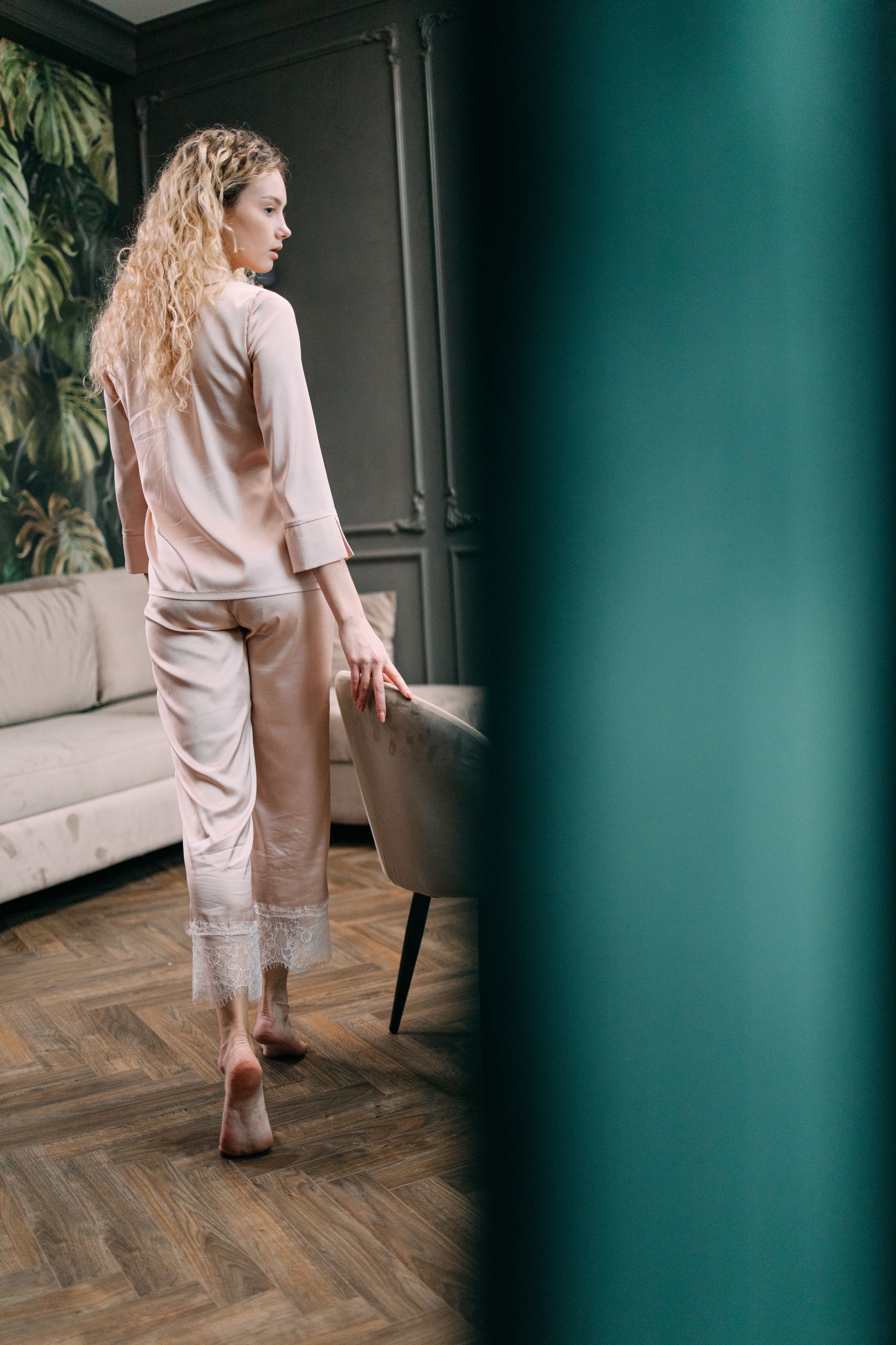 Uma jovem em pijamas elegantes caminhando em uma sala moderna e chique.