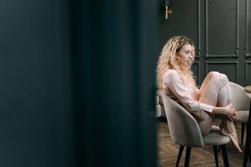 Free Woman in Sleepwear Sitting on a Chair Stock Photo