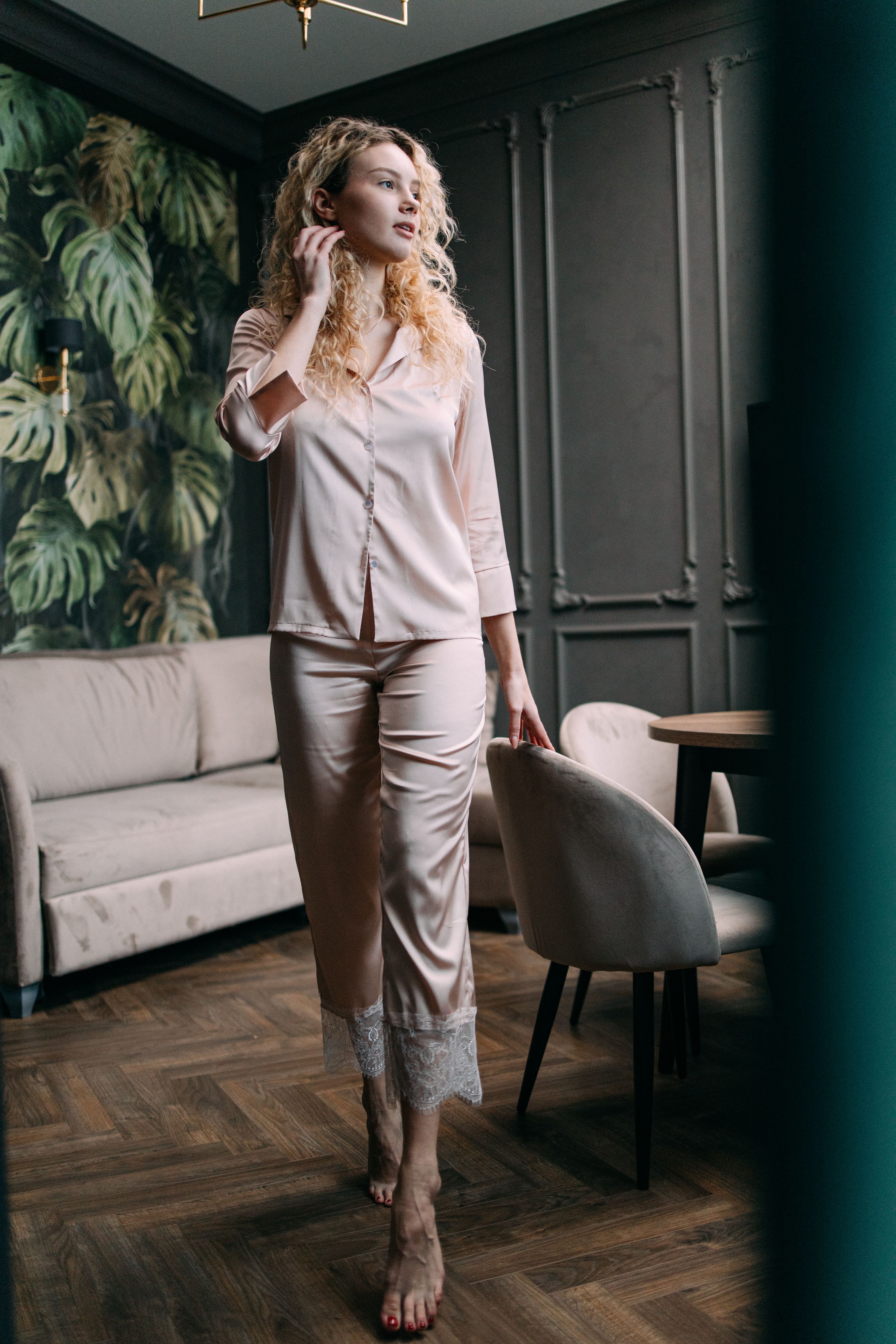 Mulher estilosa vestindo pijamas de seda em um ambiente moderno, exalando elegância.