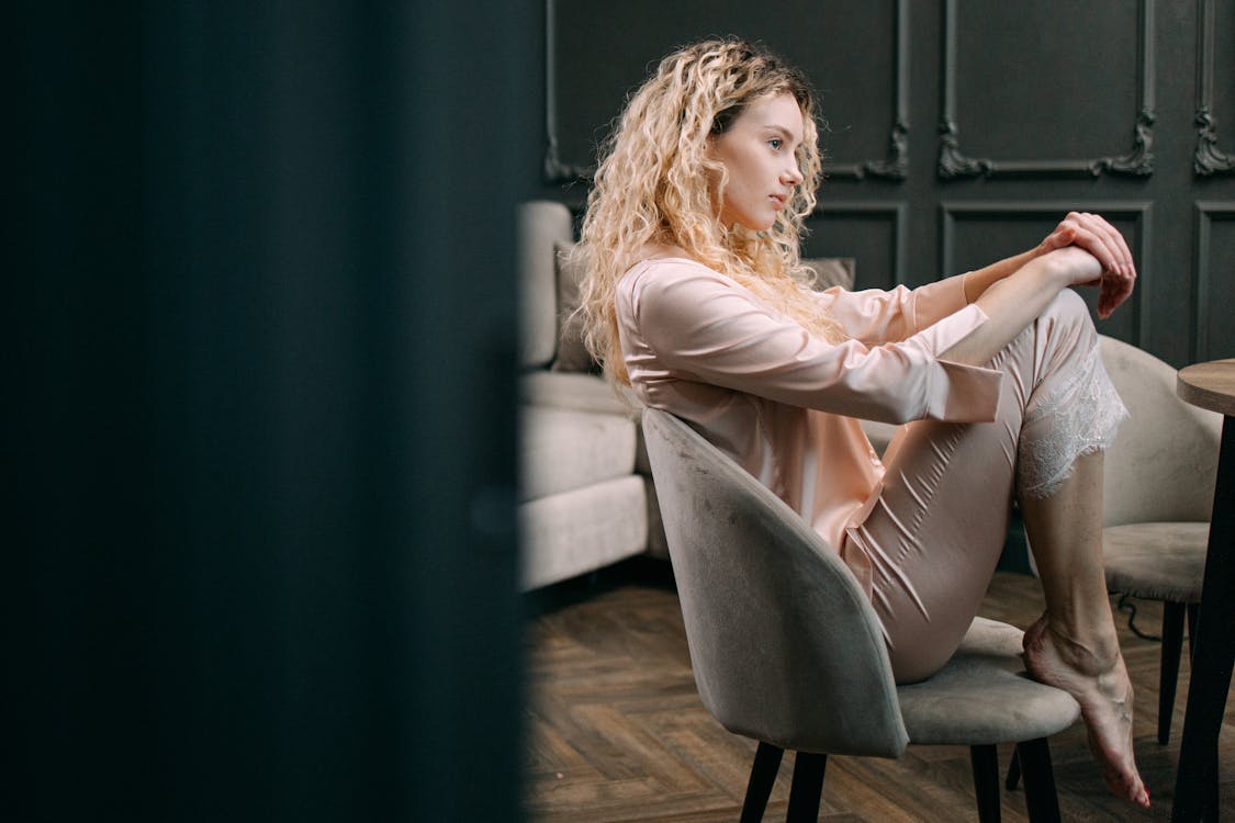 Free A Woman in Her Pajamas Sitting on a Chair  Stock Photo