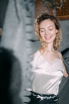 A cheerful woman in elegant loungewear, enjoying a relaxing moment indoors.