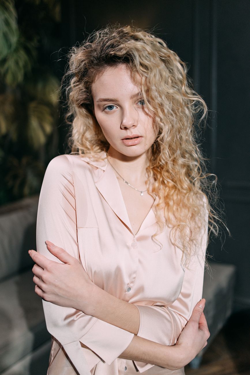 Portrait of a woman in elegant pink loungewear indoors, exuding grace and relaxation.
