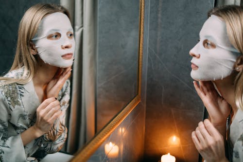 Free A Woman With Sheet Mask Looking at the Mirror  Stock Photo