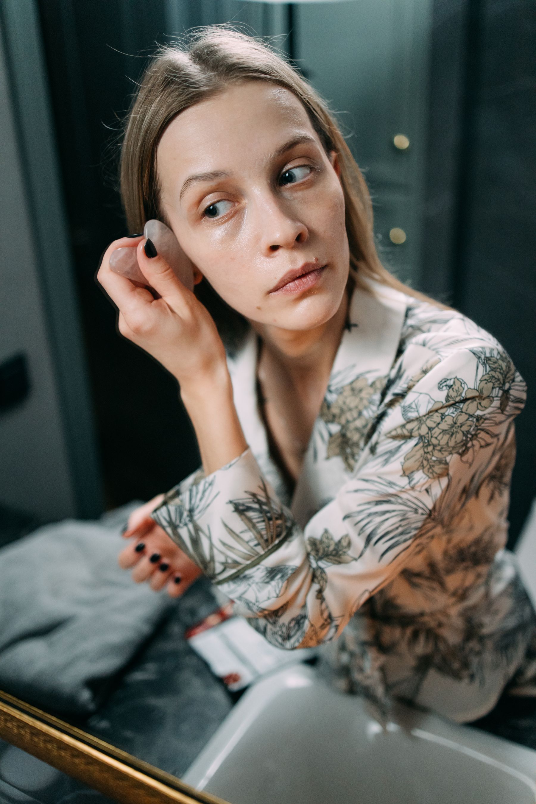 Woman applying skincare product during a quiet home bathroom routine