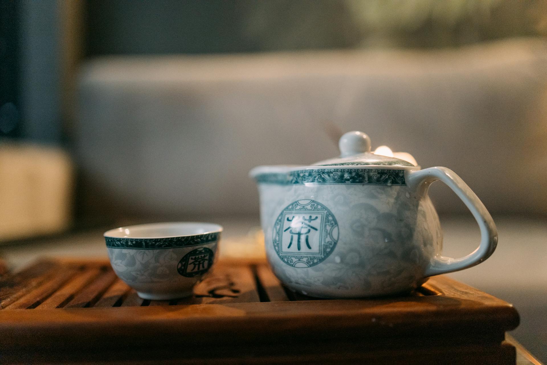 Une tasse de thé en céramique blanche sur une table en bois brun