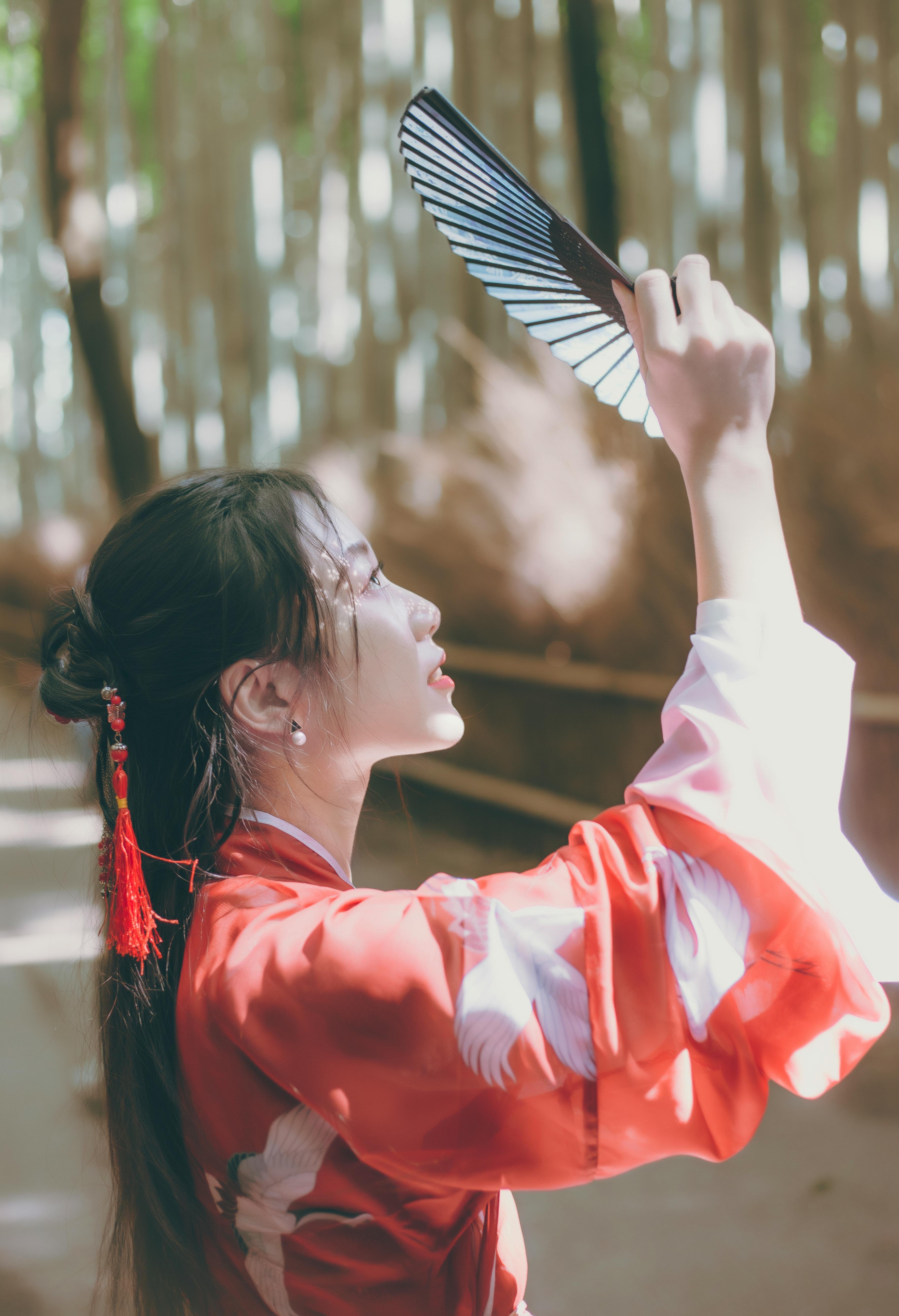 A Woman Wearing a Kimono while Holding a Hand Fan