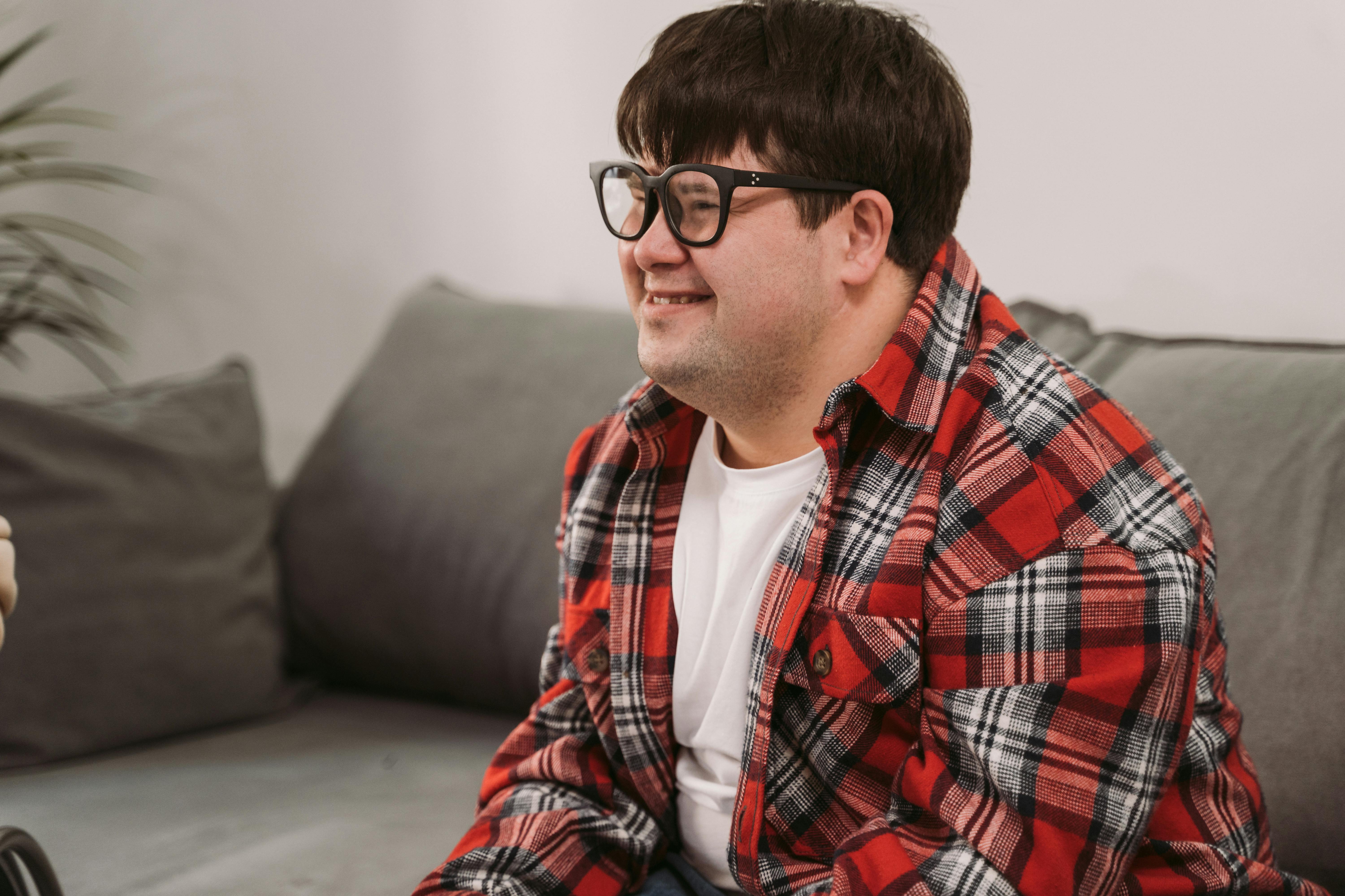 boy in red white and black plaid dress shirt wearing black framed eyeglasses