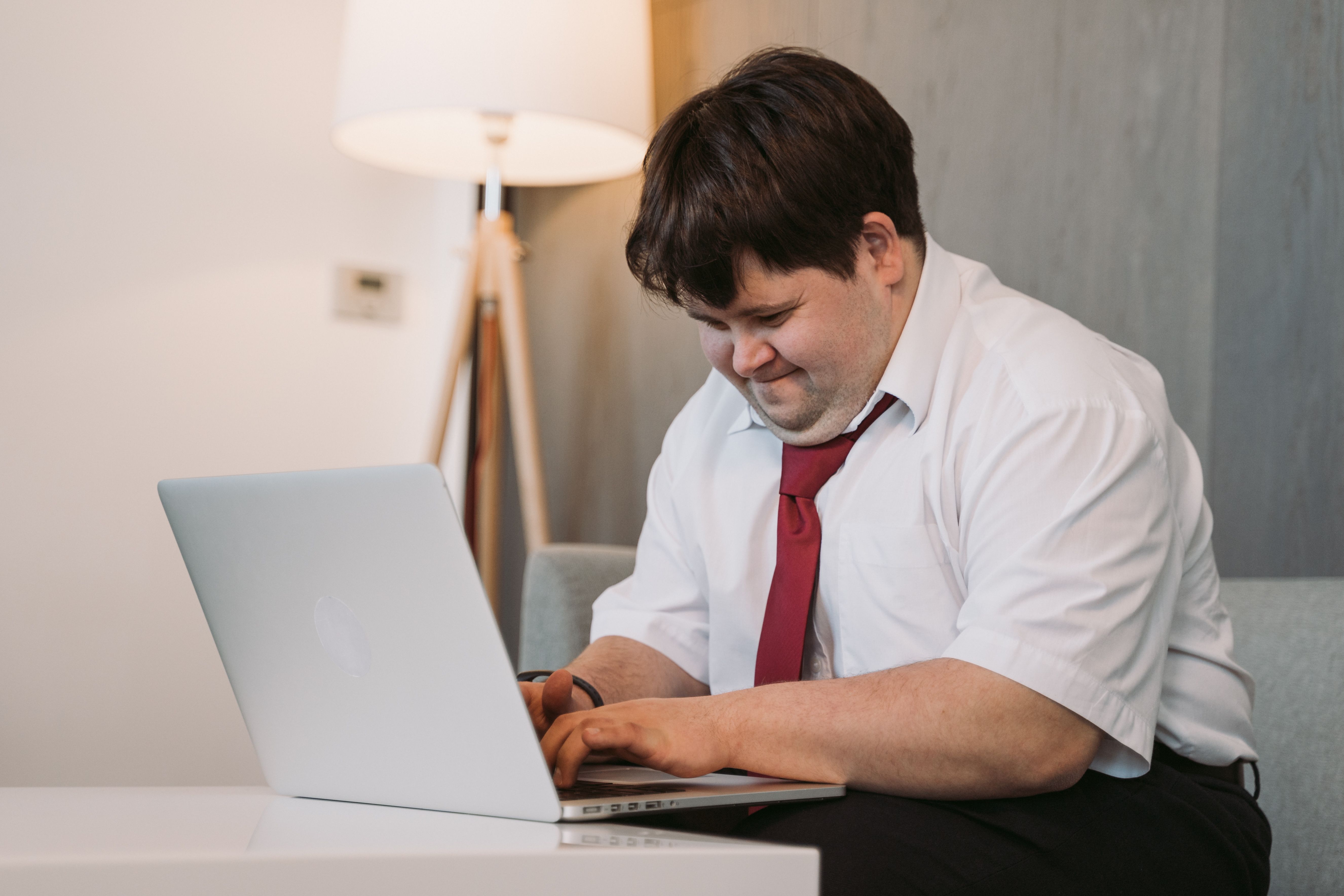 Adult with Down syndrome using a laptop independently at home