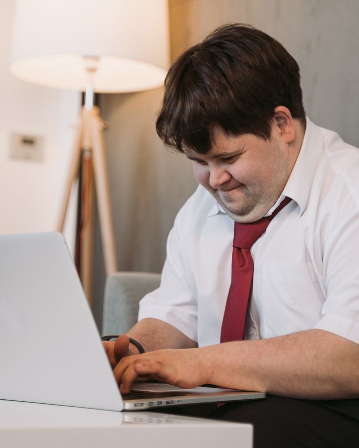 Adult with Down syndrome using a laptop independently at home