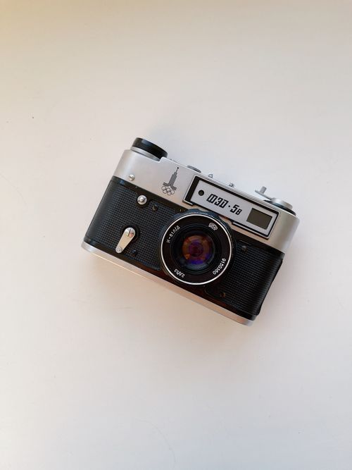 Free From above of old fashioned analog photo camera placed on white table surface Stock Photo