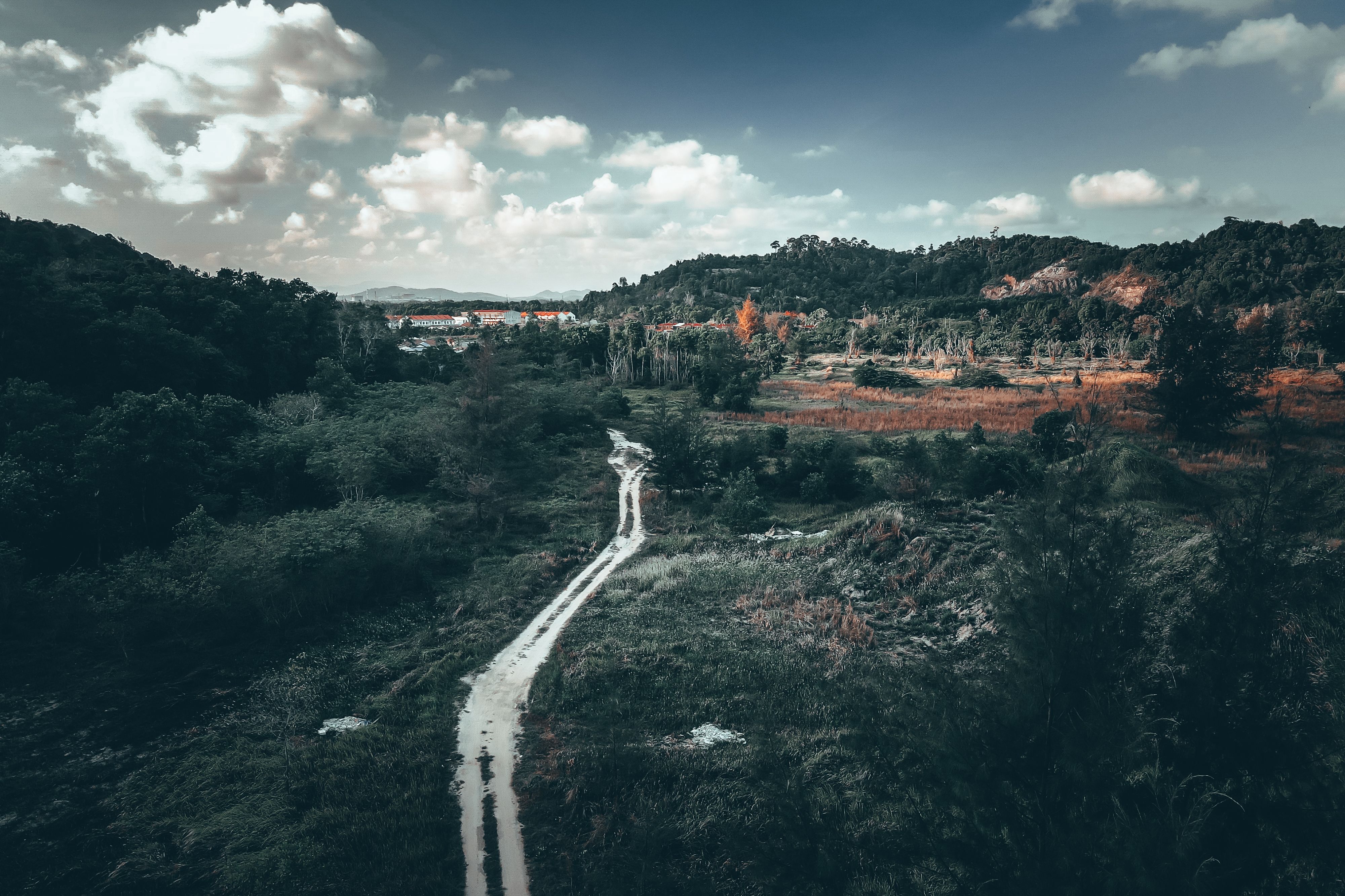 Stunning aerial view of Chukai's lush greenery, rolling hills, and cloudy sky in Terengganu, Malaysia.