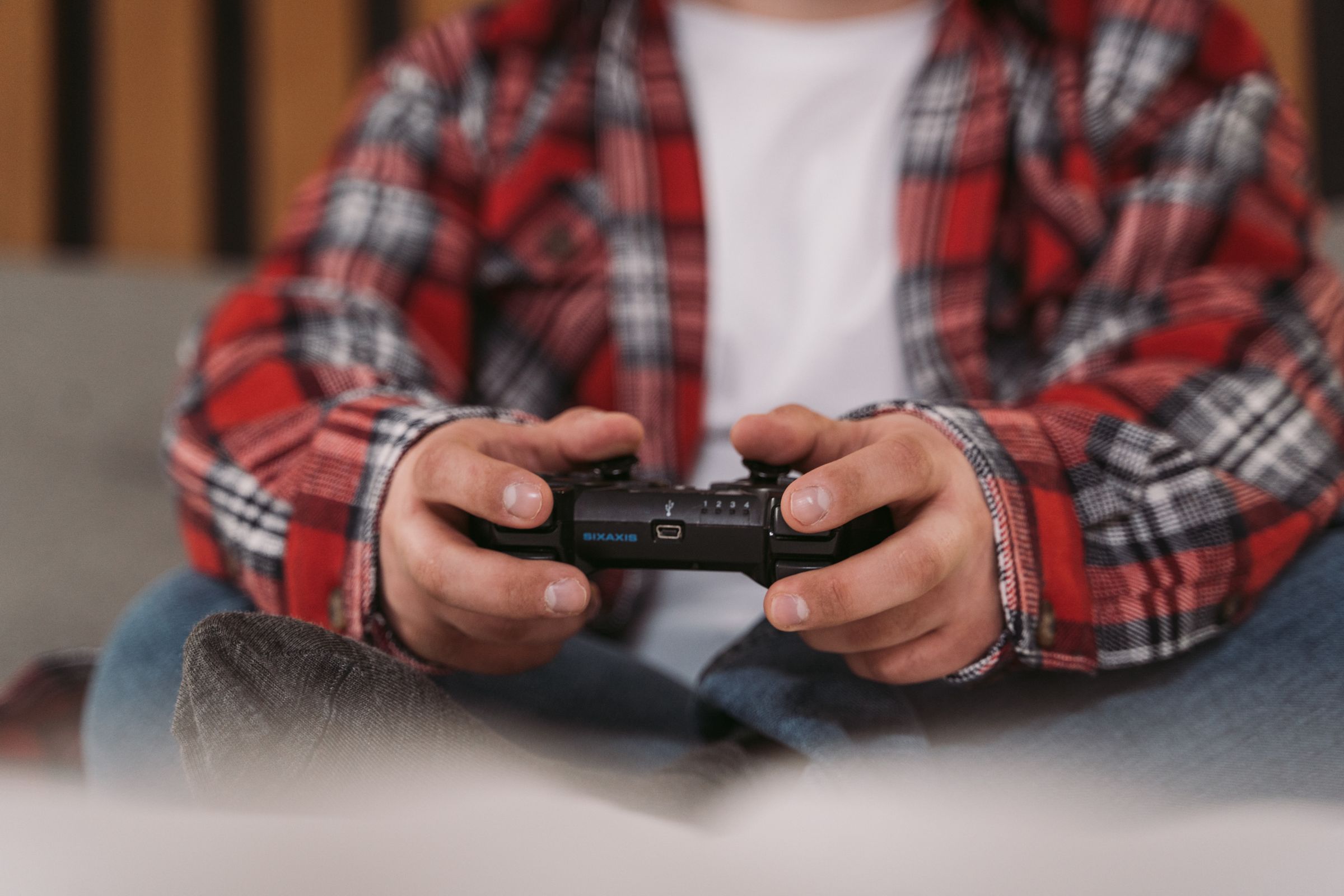 Close view of hands using a black game controller