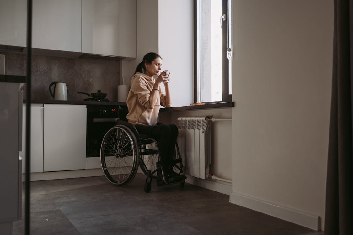 Free Woman Sitting on Wheelchair while Drinking Coffee Stock Photo