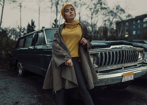 Woman in Yellow Turtleneck Shirt and Gray Jacket Standing beside a Car