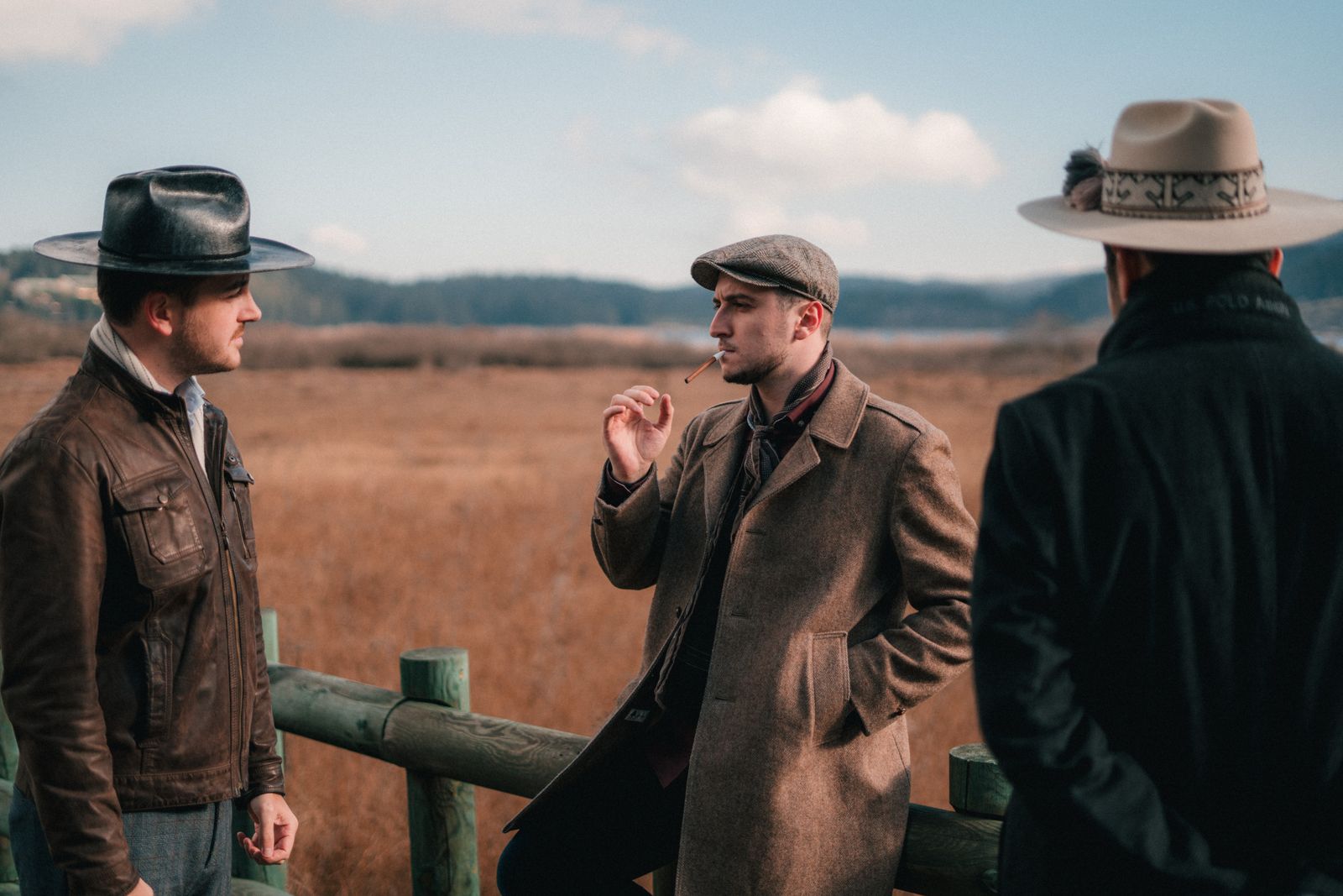 Three figures in vintage western clothing outdoors