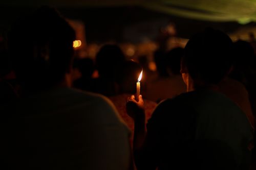 Free Intimate night scene of people holding candles at a gathering in Yangon, Myanmar. Stock Photo