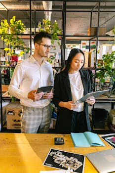 Two professionals collaborate in a modern office setting, reviewing documents with focus.