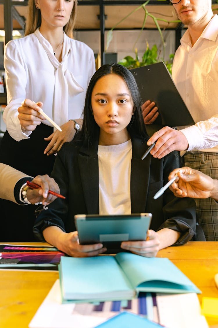 Woman Using Ipad Brainstorming With Her Colleagues