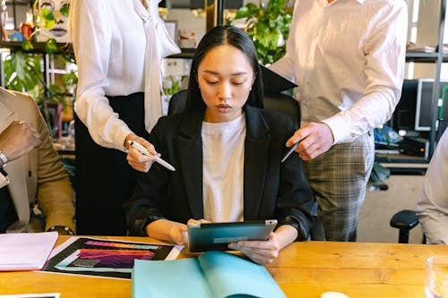 Free Woman Using Ipad Brainstorming with Her Colleagues Stock Photo