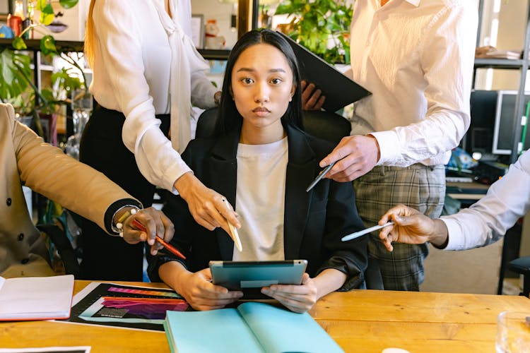 Woman Using Ipad Brainstorming With Her Colleagues