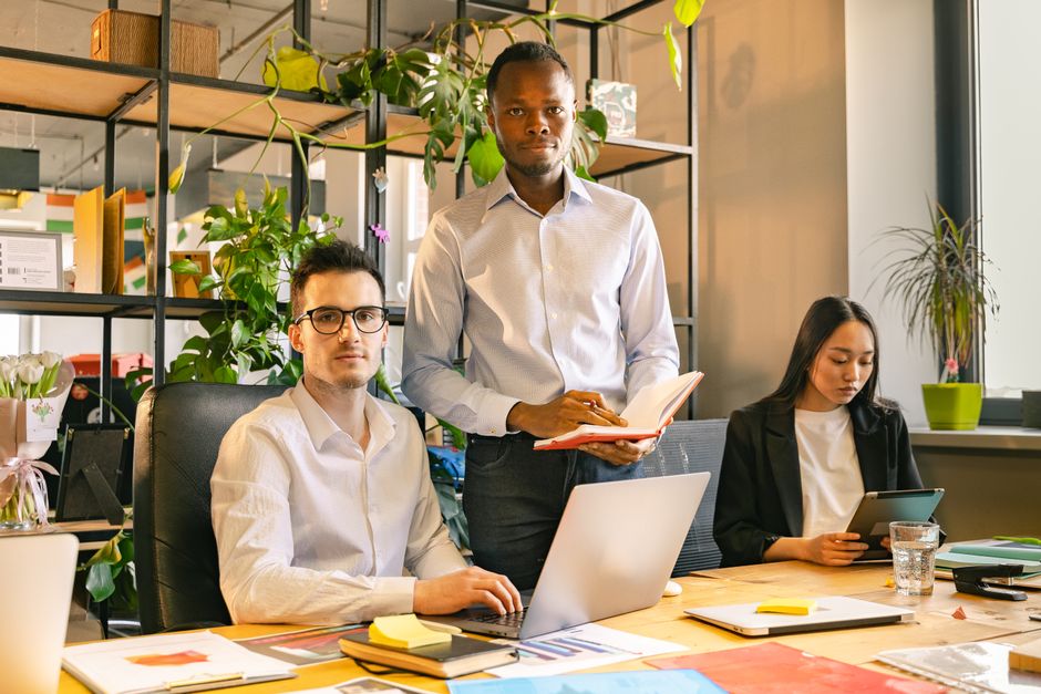 Team arbeitet zusammen im Büro an Laptops