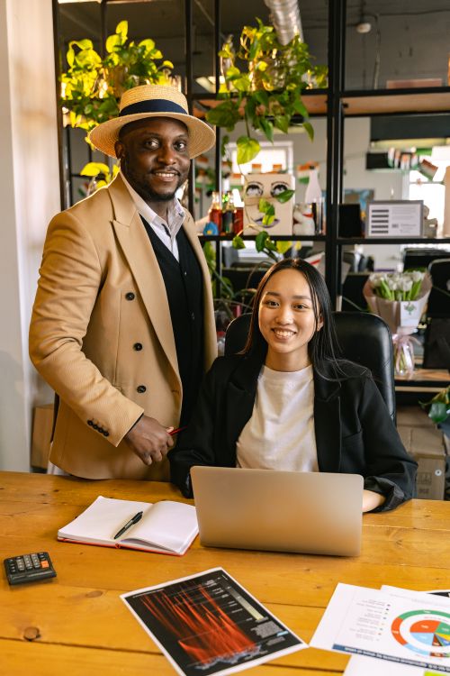 Free Two coworkers collaborating in a vibrant office setting with a laptop. Stock Photo
