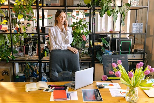 Woman Talking Through the Phone in a Contemporary Office Full of Houseplants 