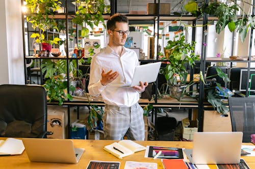 Man Taking Video Call on Laptop in Office