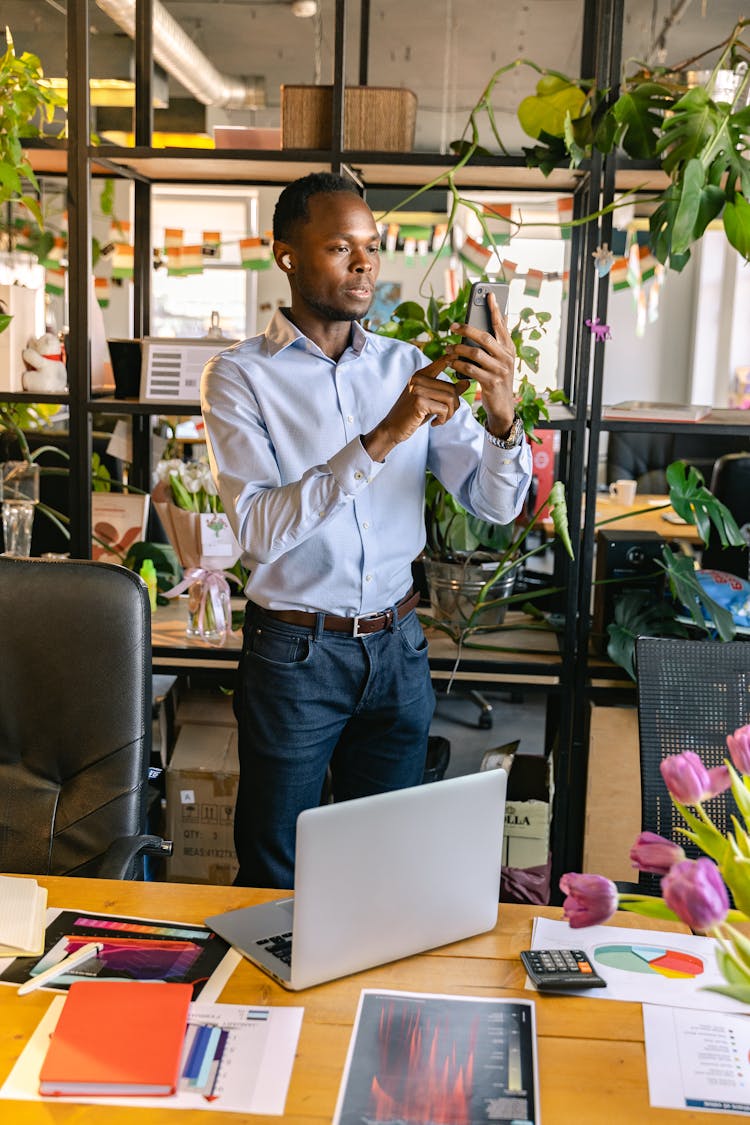 Man Standing In An Office And Using Phone 