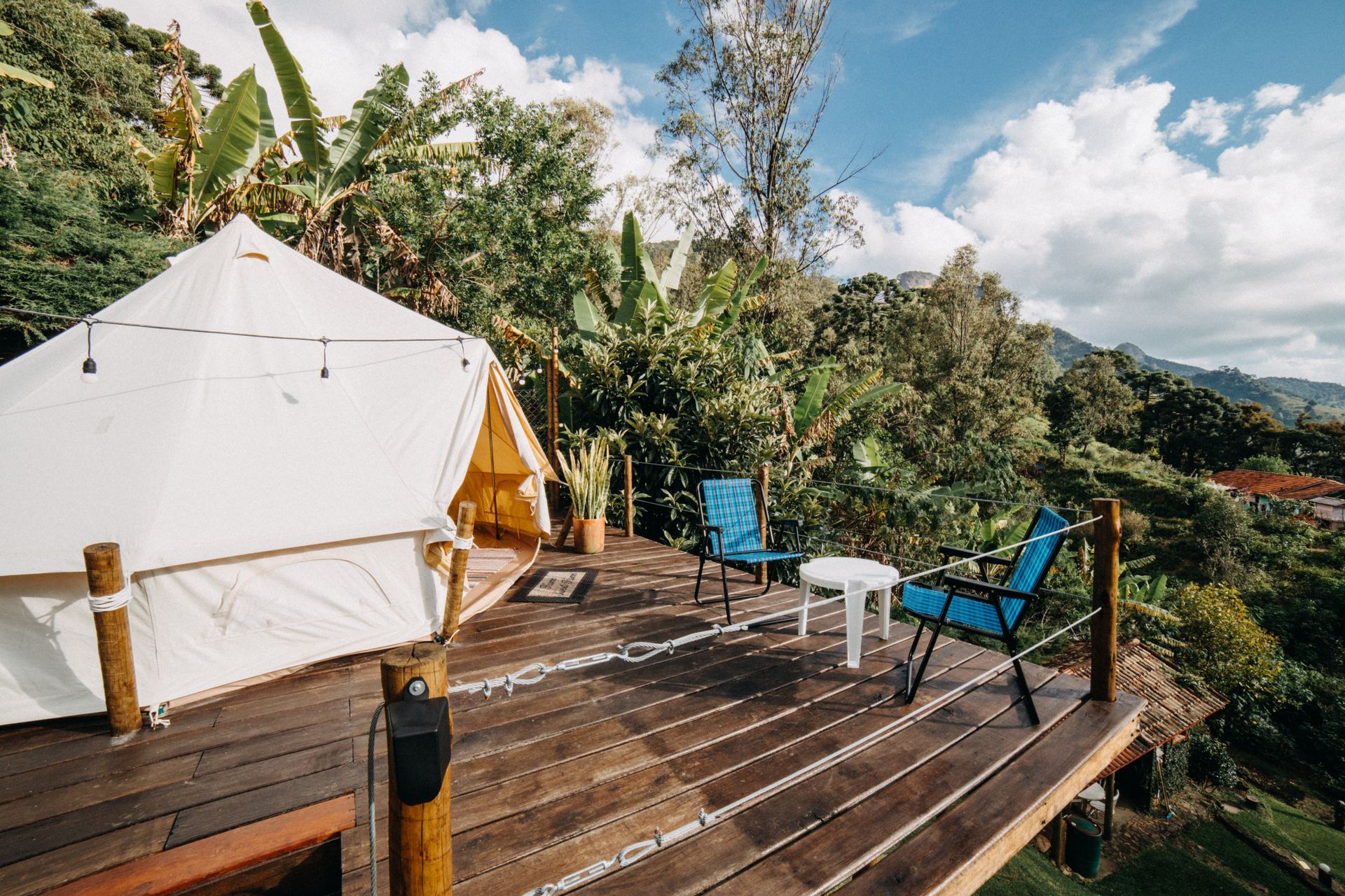 Tenda glamping con veranda in legno immersa nel verde della Valtellina