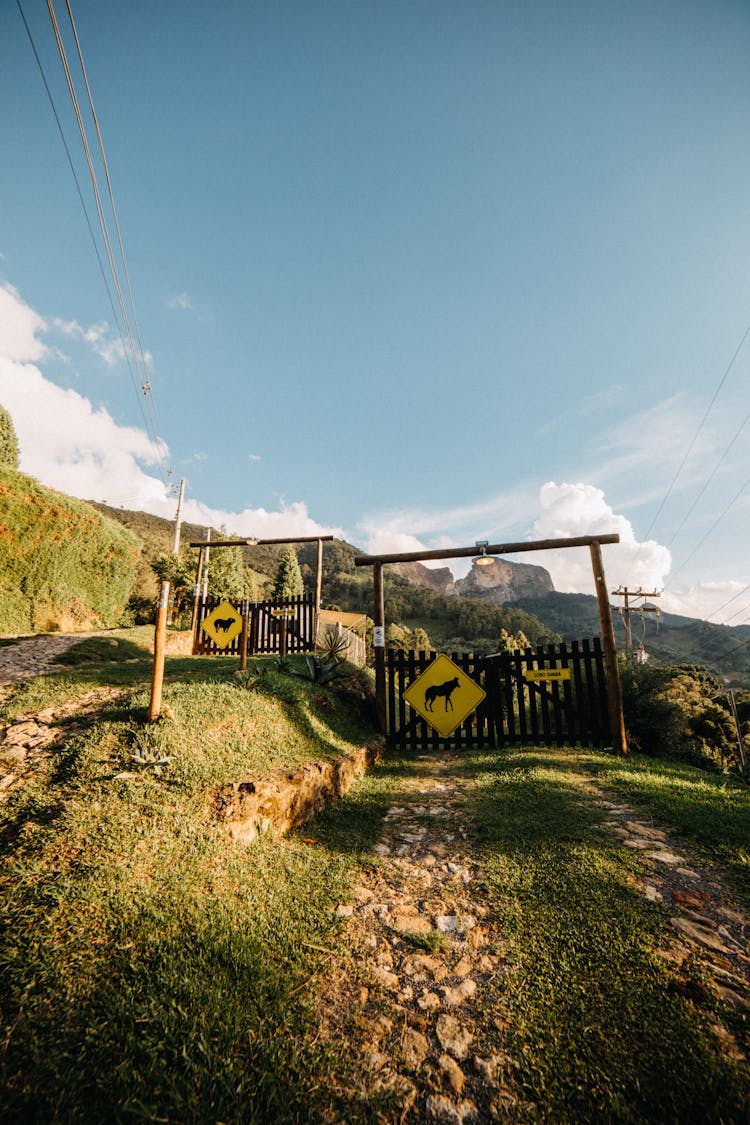 Animal Farm With Wooden Gates And Yellow Signs