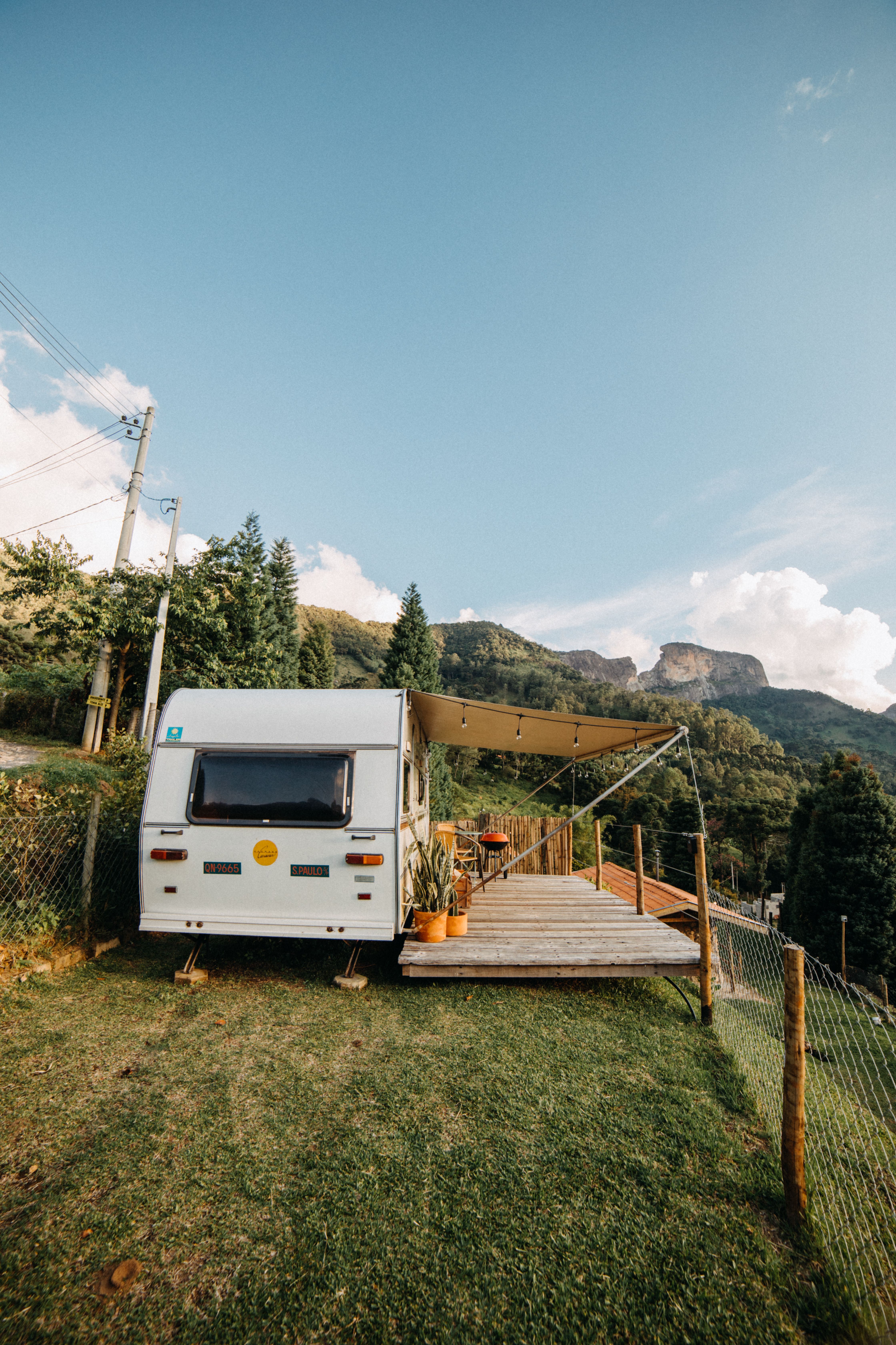 Wohnwagen auf einem grasbewachsenen Hang mit Markise, eine typische Off-Grid-Konfiguration, betrieben mit einer 24V-100Ah-LiFePO4-Batterie