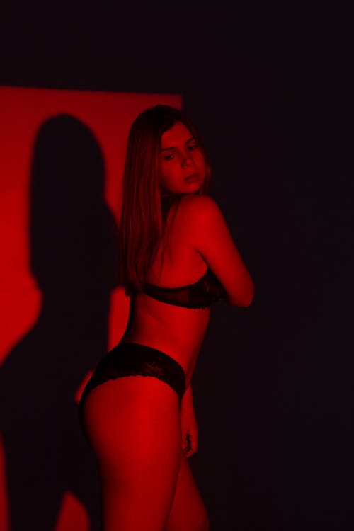 Female in underwear in dark room with red light