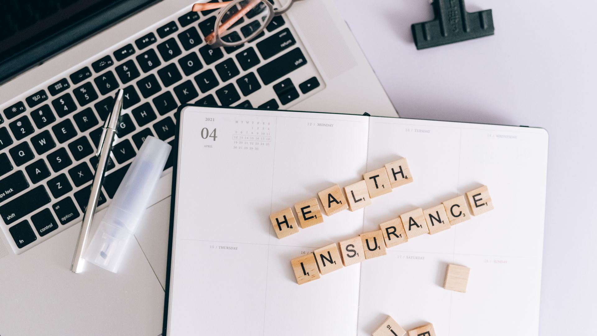Modafinil Insurance Coverage Guide: Unlocking Your Benefits Scrabble tiles spelling health insurance on a planner next to a laptop — modafinil insurance coverage guide