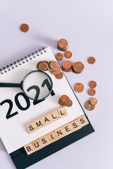 Flat lay of coins, magnifying glass, and a calendar for small business concept.