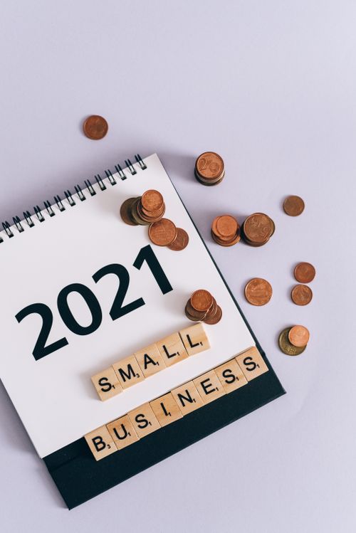 Free A 2021 calendar page with coins and scrabble pieces spelling 'SMALL BUSINESS'. Stock Photo