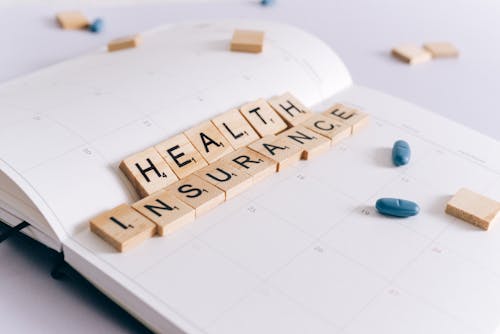 Free Health Insurance Scrabble Tiles on Planner  Stock Photo